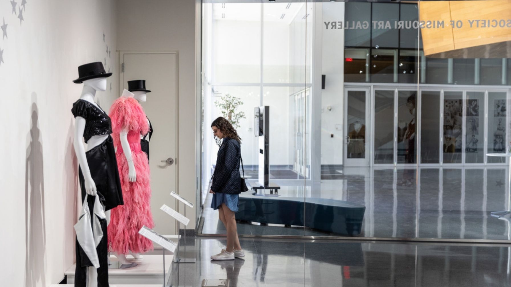 A photo of a lady looking at designs for dresses