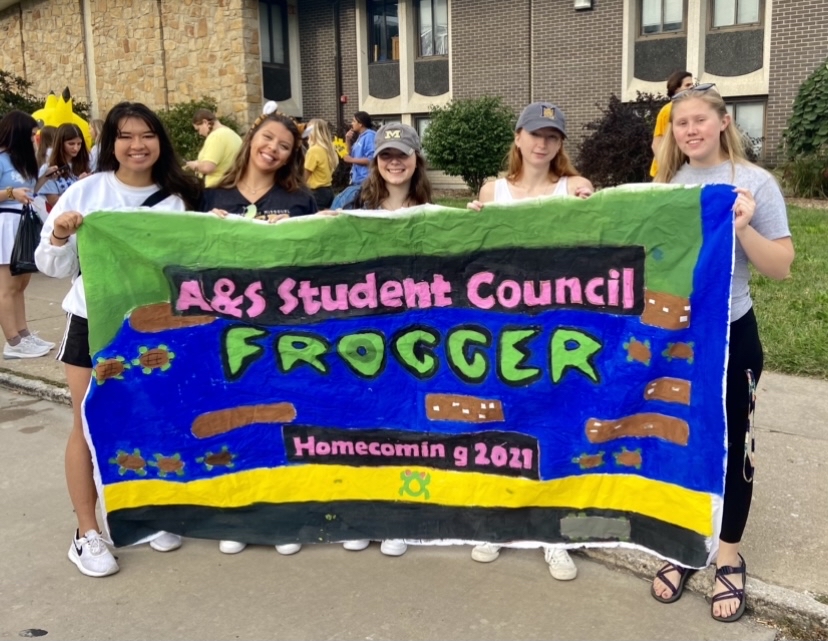 StuCo members holding a homecoming banner