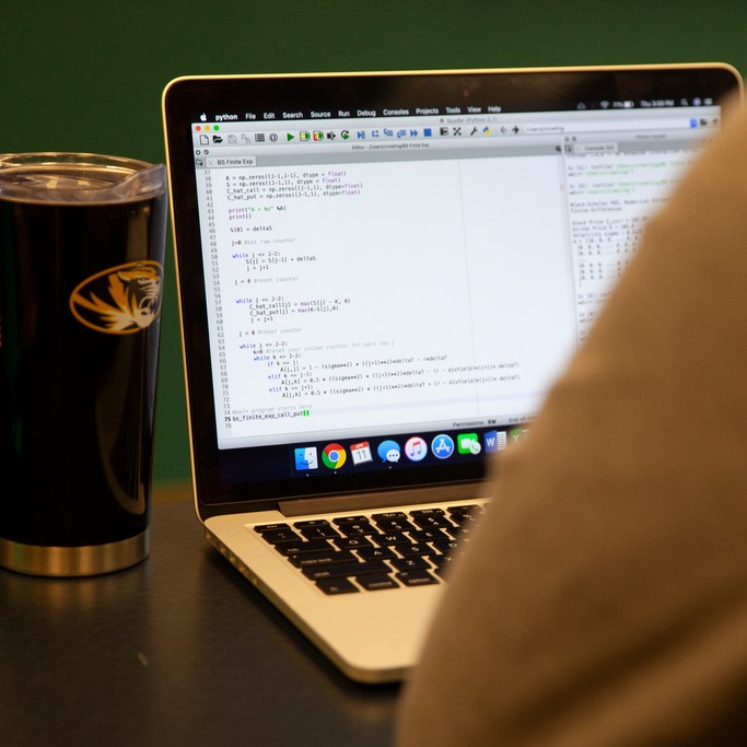 photo of laptop on desk beside coffee mug