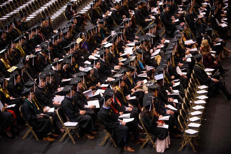 Graduates in caps and gowns at graduation.