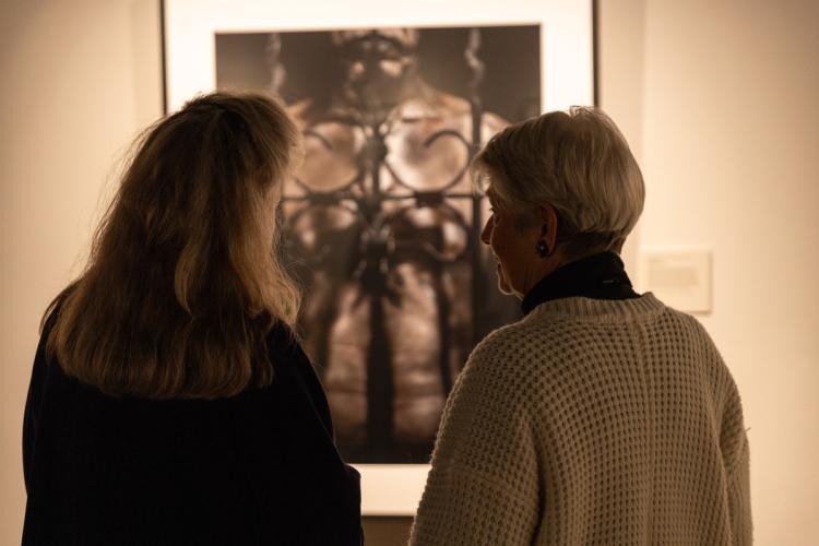 two women looking at photo on museum wall 