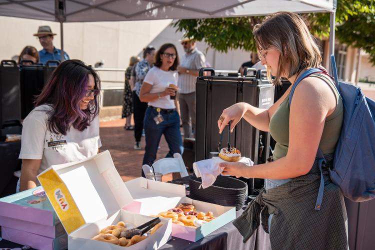 attendee picks up donut from box