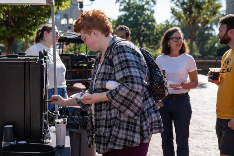 attendee pours coffee into cup