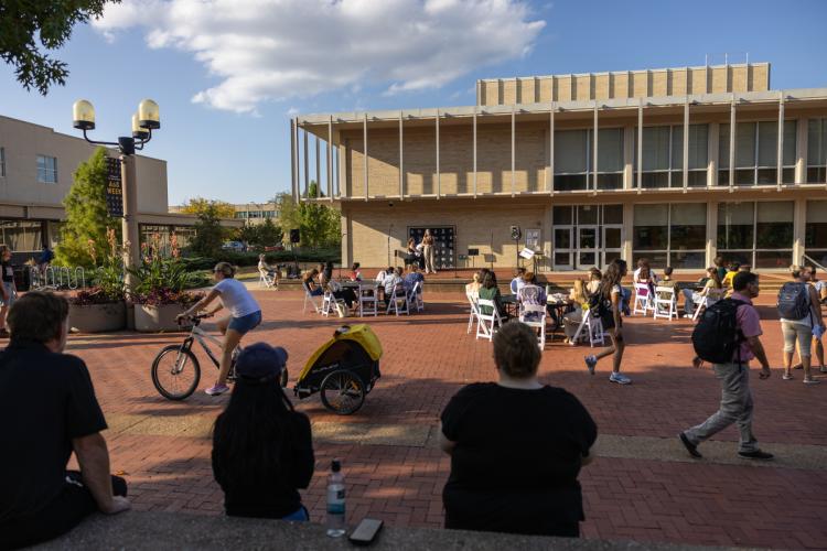 Attendees sit and stand on Lowry Mall listening to music