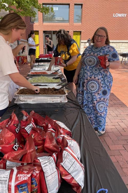 staff member standing at table with taco ingredients