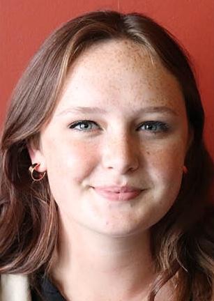 Marin Chamberlin, a young woman smiling, in front of a red backdrop 