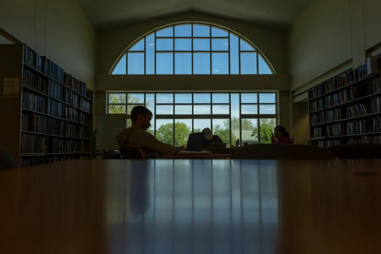 A photo of a student sitting by a table in the dark room