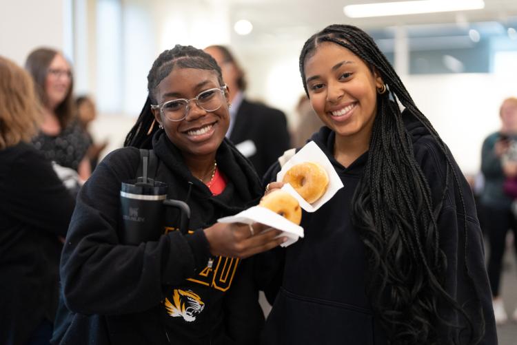 A photo of two students with donuts smiling