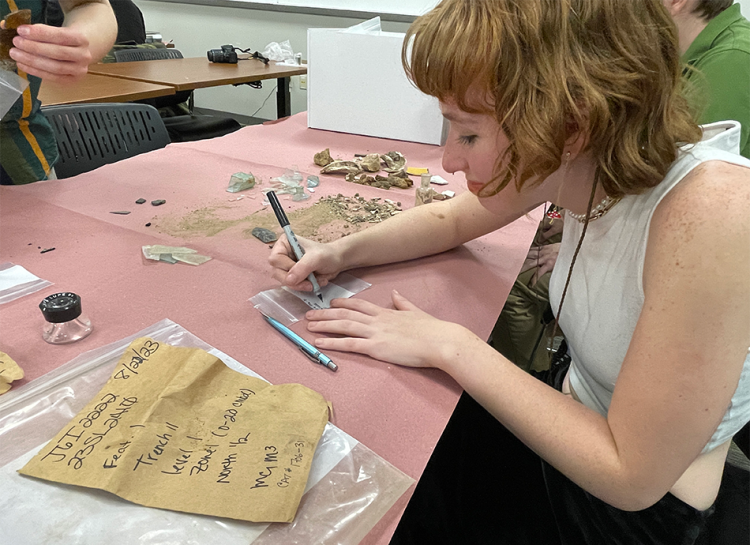 student makes a list of items found in a privy