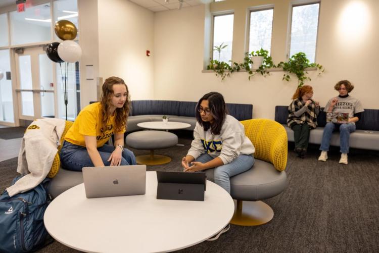 A photo of a staff member helping a student with coaching in a classroom